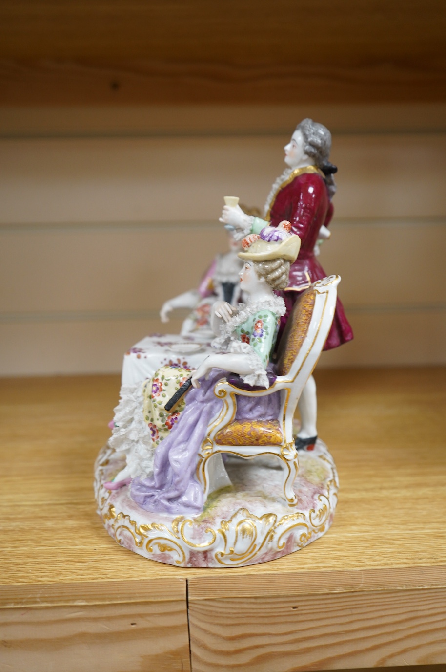 A large German porcelain ‘Tea Party’ group, 25cm high. Condition - has broken and been re-glued